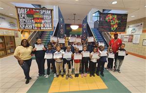 Elementary students standing and holding certificates